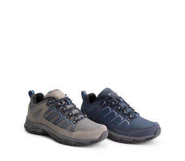 Blauwe en grijze Travelin wandelschoenen naast elkaar met sportief design en stevige zolen.