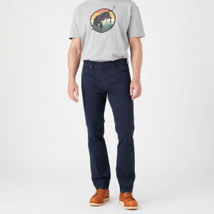 Het model draagt de Wrangler Greensboro Amberglow Tree Jeans.