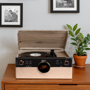 Sfeervolle interieurfoto van de Denver MRD-180 op een houten kast met een vinylplaat, plant en wanddecoratie op de achtergrond. Sfeervolle interieurfoto van de Denver MRD-180 op een houten kast met een vinylplaat, plant en wanddecoratie op de achtergrond.