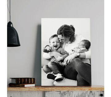 Een canvas heeft een foto van een moeder en haar 2 kinderen er op gedrukt. 