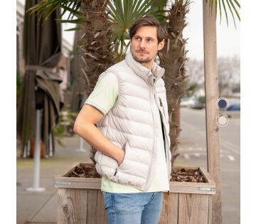 Een man draagt de Mario Russo bodywarmer in de kleur beige, de bodywarmer is verkrijgbaar in crème en marineblauw. 