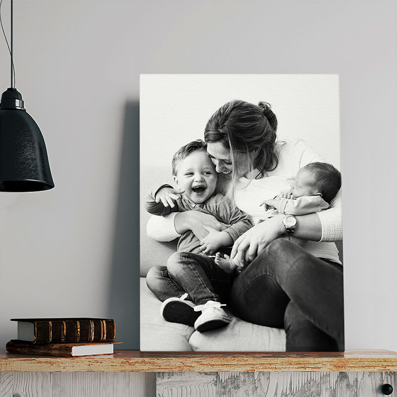 Een canvas heeft een foto van een moeder en haar 2 kinderen er op gedrukt. 