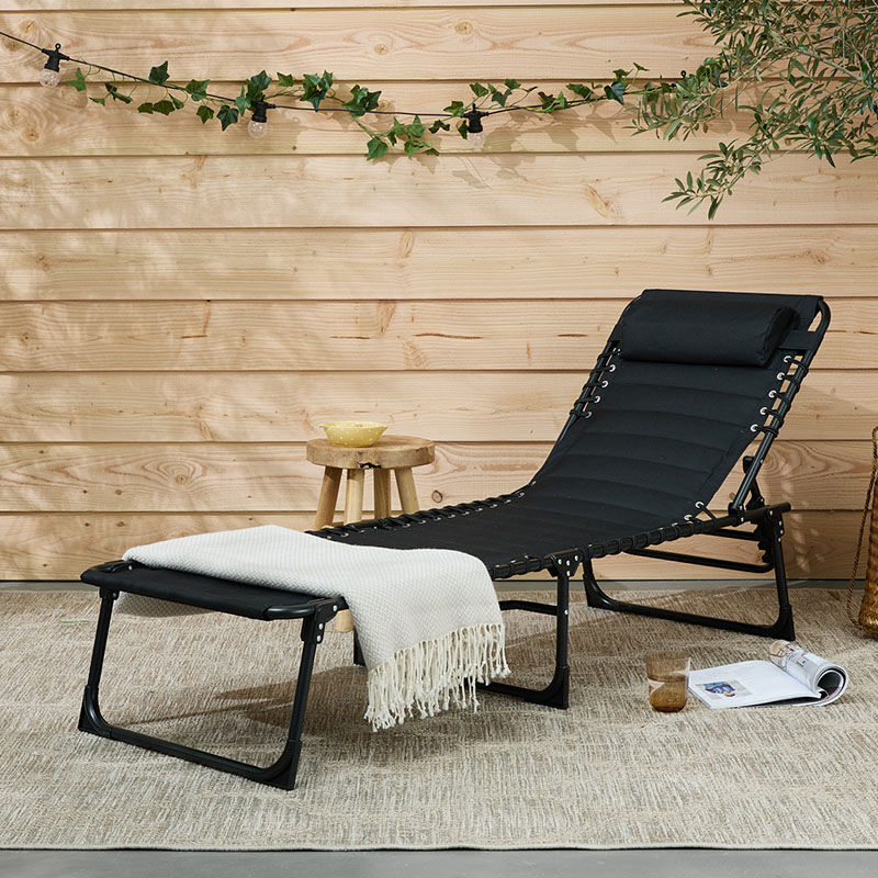 Het 909 Outdoor Ligbed met Padding staat in de tuin.