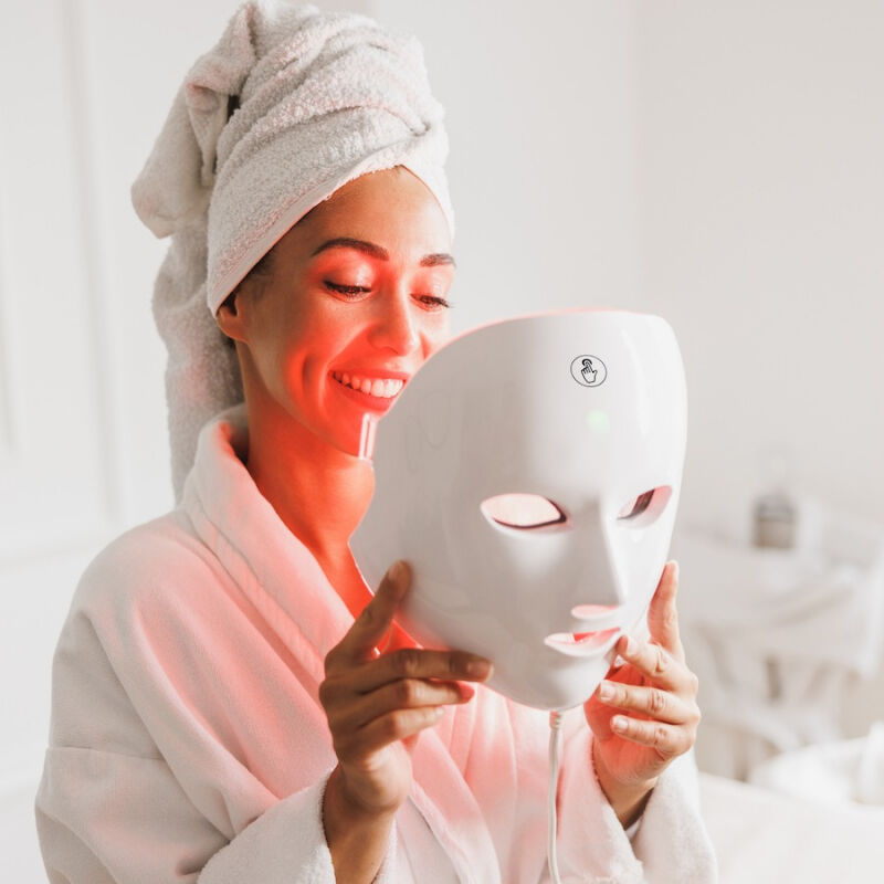 Een vrouw gaat het MOSS Gezichtsmasker met lichttherapie opzetten. Een vrouw gaat het MOSS Gezichtsmasker met lichttherapie opzetten.